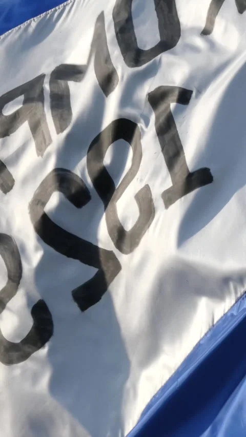 Waving white fabric flag featuring bold black painted text patterns, wind m.. Stock Footage 345198534