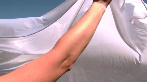 Waving white sheet slow motion in field of flowers Vídeo Stock 144083588