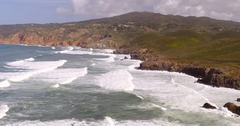 Wavy beach on a cloudy day near mountains Push Out Guincho Aerial drone Stock Footage 87538995