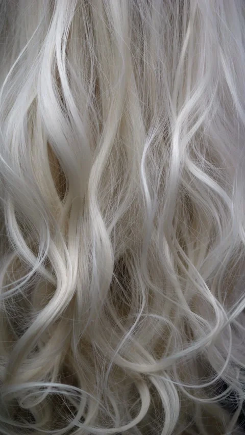 Wavy blond hair flows on the screen. Curls fill the screen, creating textur.. Video stock 282710845