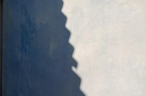 Wavy diagonal shadow on rough uneven wall. The gray exterior wall of the buil Stock Photos