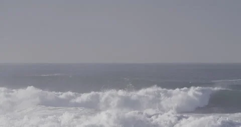 Wavy ocean waves splashing and breaking on sandy beach on sunny day in Nazare Video stock 160758050