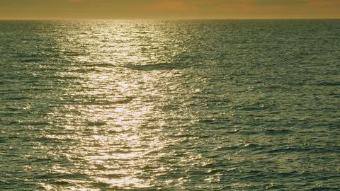 Wavy Water Surface Background With Ripples And Glares. Golden Glittering Sea Stock Photos