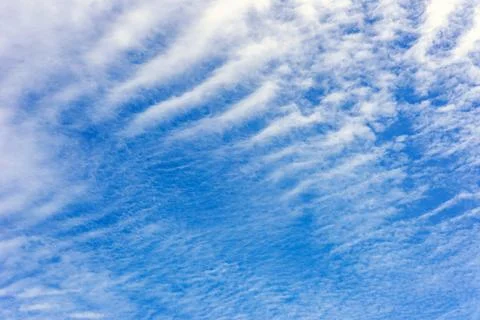 Wavy white clouds spread in the blue sky. Sky background. Stock Photos