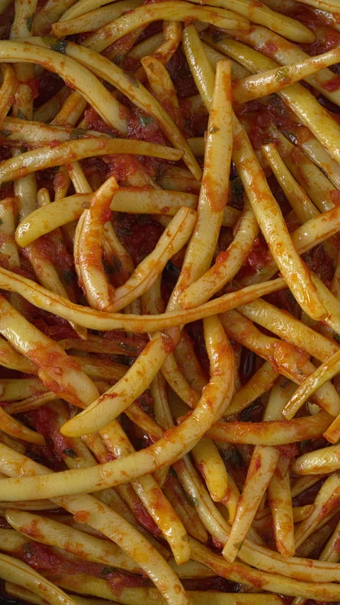 Wax beans with tomatoes and olive oil as background texture. Vertical video. Stock Footage 314077250