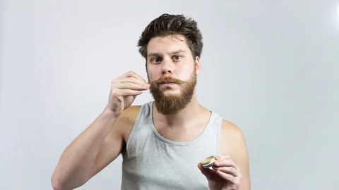 Wax for the care of the beard.A man puts his mustache with wax.Men's cosmetics Stock Footage 122372957