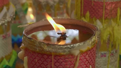 Wax melts and drips down a colorful burning candle in a Buddhist temple Stock Footage 318686233