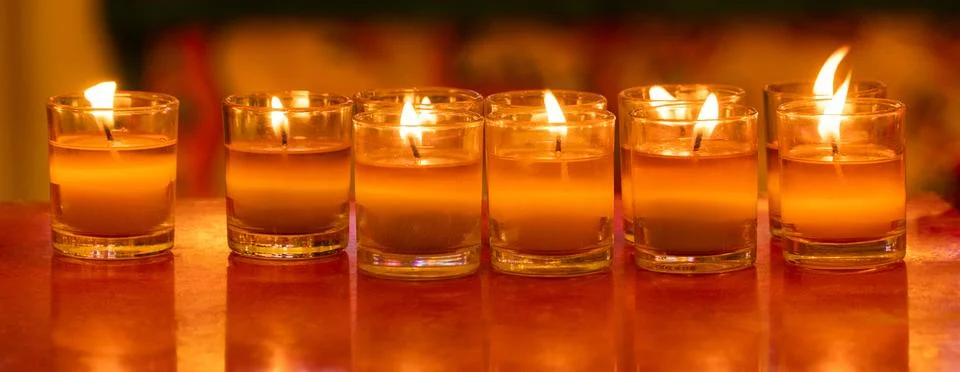 Wax with string in several small glasses was lit as a candle. Stock Photos