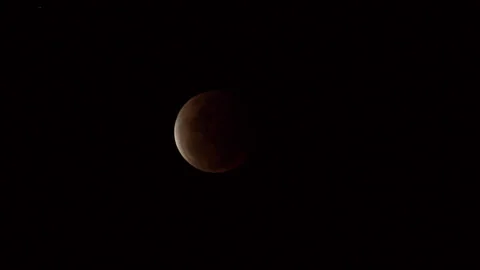 A waxing crescent moon, with a sliver of light illuminating one side of the Stock Footage 332780959