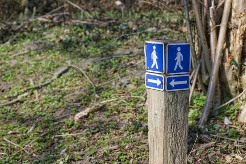 Wayfinding post with opposing pedestrian arrows in park Stock Photos
