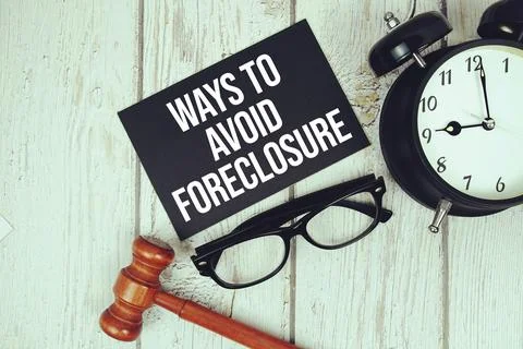 Ways To Avoid Foreclosure text on paper card with alarm clock and wooden ju.. Stock Photos