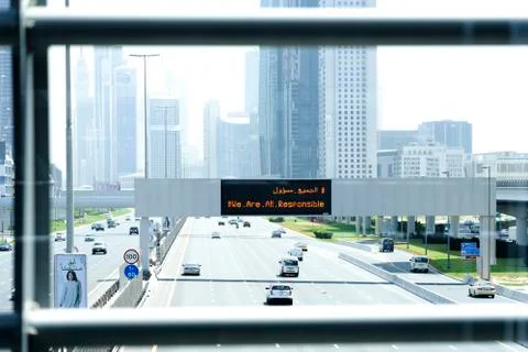 "We are all responsible" text seen on a notice board over a highway. COVID-19 Stock Photos