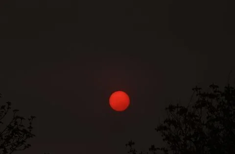 We are not observing the moon, but the red sun in a polluted atmosphere. Stock Photos