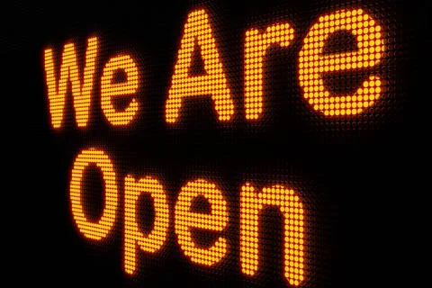 We are open. Dark LED screen with the word We are open in orange glowing l... Fotos de archivo