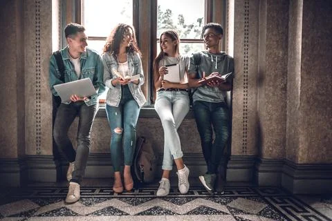 We are ready for exams!Multiracial students standing near window and preparin Stock Photos