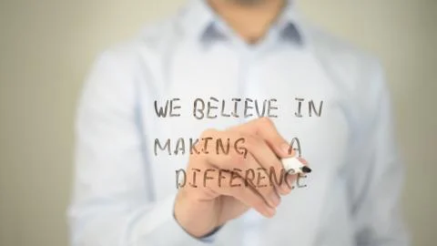 We Beleve In Making A Difference , man writing on transparent screen Stock Photos