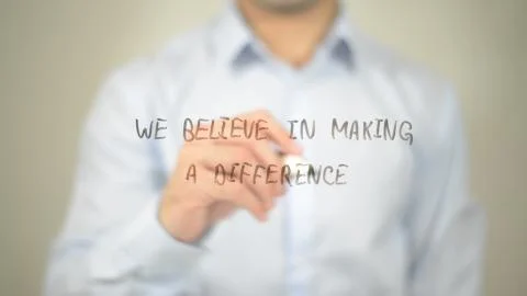 We Believe In Making A Difference , man writing on transparent screen Stock Photos
