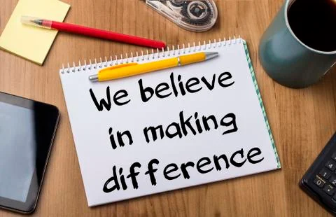 We believe in making difference - Note Pad With Text On Wooden Table Stock Photos