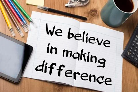 We believe in making difference - Note Pad With Text On Wooden Table Stock Photos