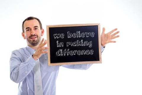 We believe in making difference - Young businessman with blackboard 写真素材
