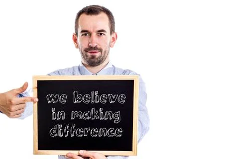 We believe in making difference - Young businessman with blackboard 写真素材