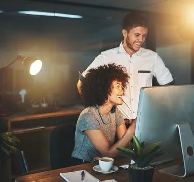 We can do this all day long. young employees working late into the evening. Stock Photos