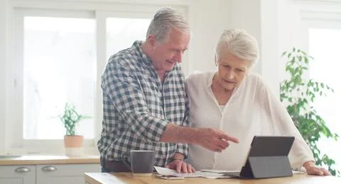 We can even do the application online. a senior couple using a digital tablet Stock Photos