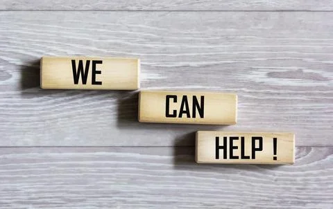 We can help with a message written on wooden blocks with a gray background. A Stock Photos