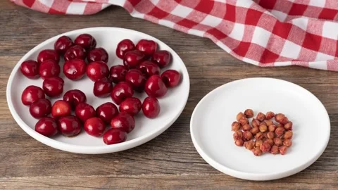We eat cherries and put the pits in an empty plate. Stop motion Stock Footage 337961483