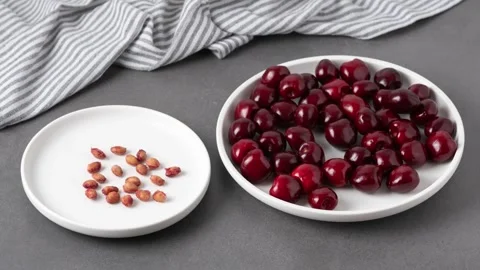 We eat cherries and put the pits in an empty plate. Stop motion animation Stock Footage 338224853