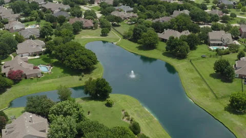 We fly over beautiful lake with water fountain in affluent Texas neighborhood Video stock 248078076