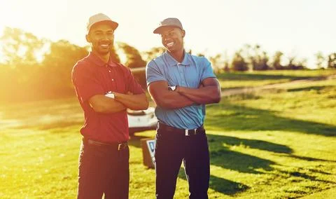 We get our daily dose of iron. two friends standing together on a golf course. Stock Photos