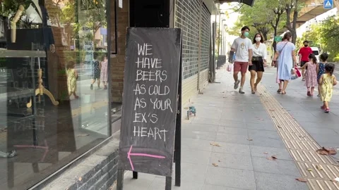 "WE HAVE BEER AS COLD AS YOUR'EX HEART" sign front store day, Bangkok Stock Footage 250145938