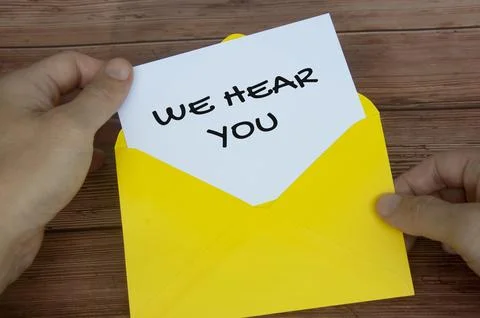 We hear you text on white notepad in yellow envelope. Listening concept Stock Photos