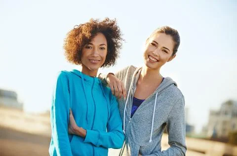 We just beat our best running record. Portrait of two female joggers standing in Stock Photos