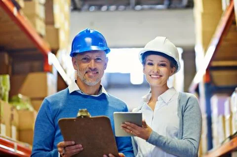 We made a great team. Two people wearing hardhats smiling at the camera in a Stock Photos