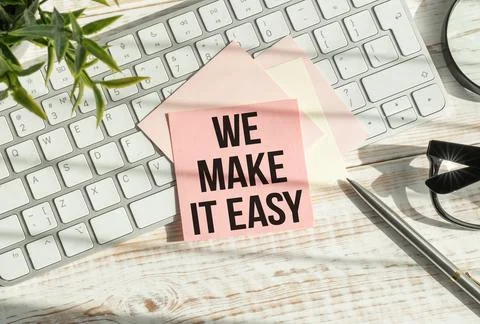 We make it easy text in the notebook on a blue table. Top view - business c.. Stock Photos