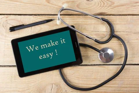 We make it easy - Workplace of a doctor. Tablet, medical stethoscope, black pen Stock Photos