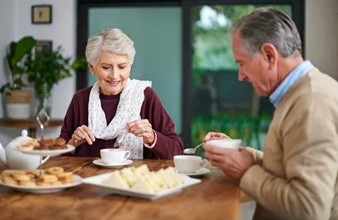 We make time for dates, even if its at home. a senior couple having lunch at Fotos Stock