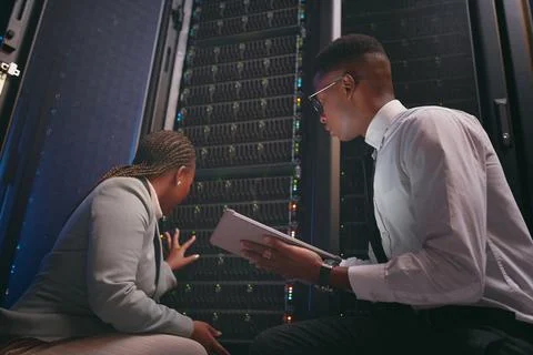 We might need to seek extra help. two young IT specialists crouched down in the 스톡 사진