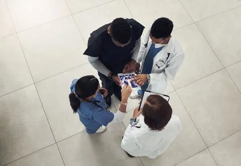 We need to have a quick meeting. a group of doctors and nurses using a digital Stock Photos