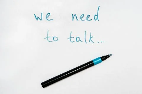 We need to talk message frase written on white piece of paper with a marker Stock Photos