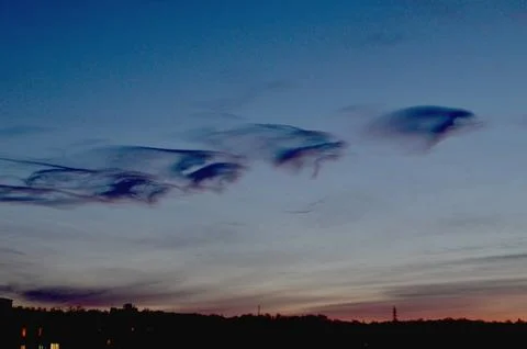 We observe strange clouds over the evening city Stock Photos