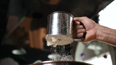 We prepare the dough for the cake by sifting flour so that the dough becomes Stock Footage 253097044