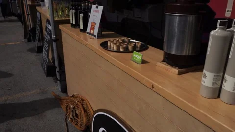 We see a person in front of a stand tasting a sample in small cups Stock Footage 306669898
