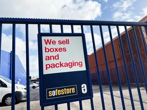 We sell boxes and packaging sign at Safestore storage facility behind blue .. Stock Photos