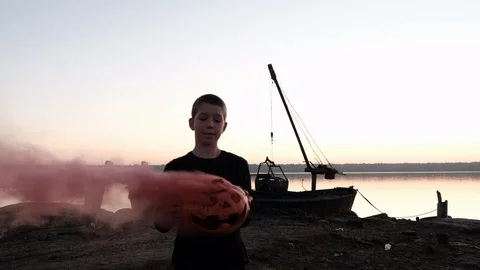 We set fire to the pumpkin on Halloween evening at sunset. Red smoke comes out o Stock Footage 102795451