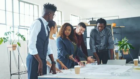 We share the workload in this office. a team of professionals working on Stock Photos