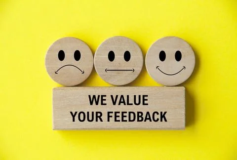We value your feedback text on wooden block with happy, sad and neutral emo.. Stock Photos