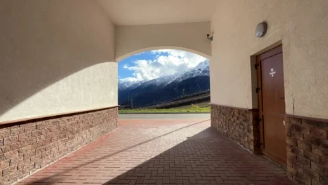 We walk through the tunnel towards an amazing mountain landscape 스톡 동영상 253470195